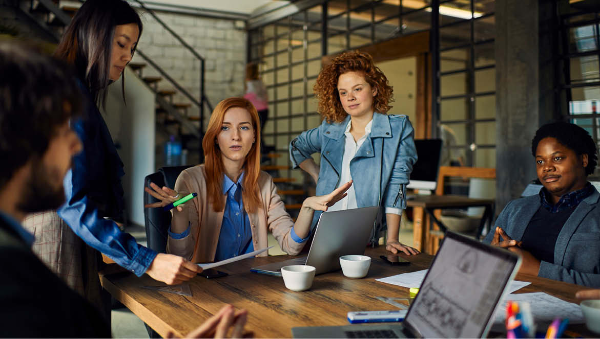 A group of people sat around a table discussing work