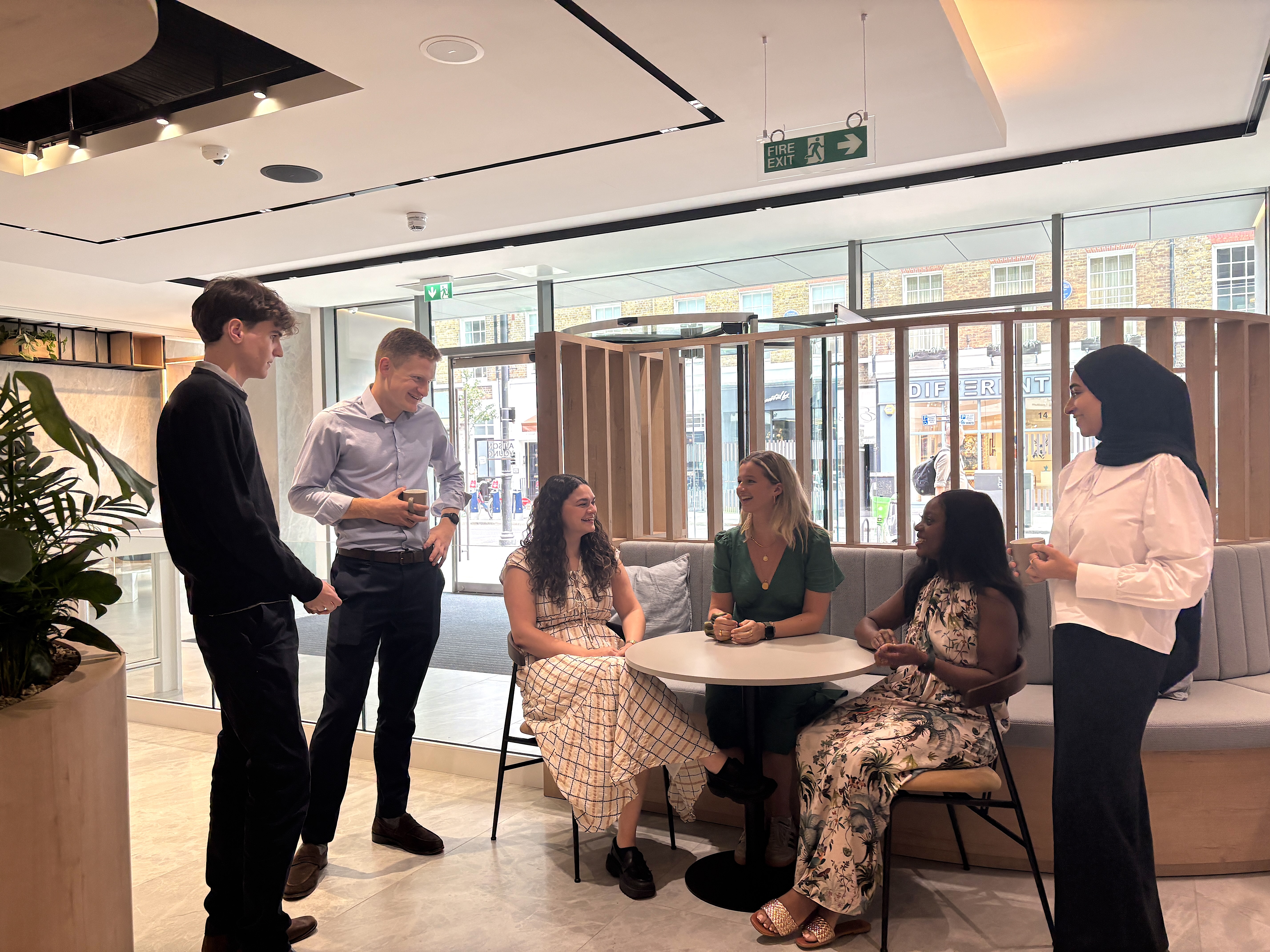 A group of young people talking in the reception of Avison Young's HQ in London