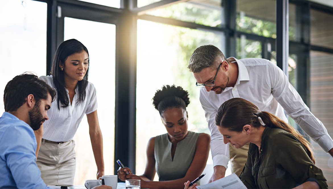 A group of people working on a project sat around a table
