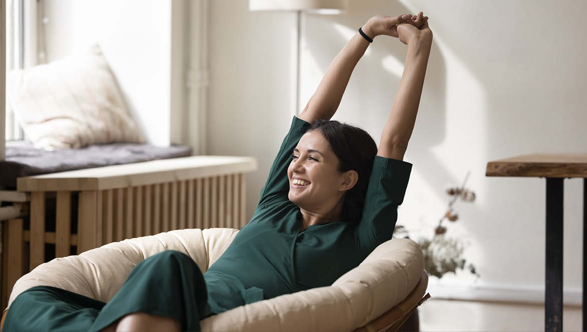 An image of a woman relaxing on a chair with her arms stretched out