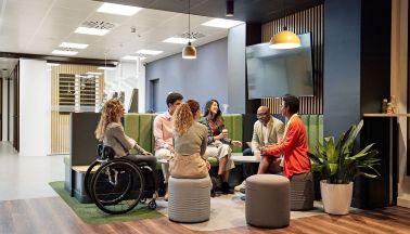 A diverse group of professionals in a modern office lounge having a collaborative discussion