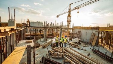 An image of construction workers on site with cranes