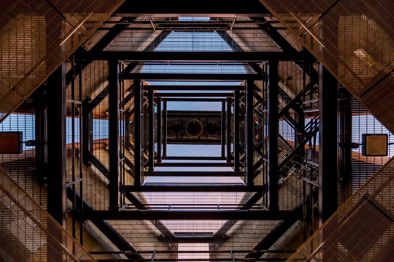 Stacked metal staircase structure forming a geometric shape