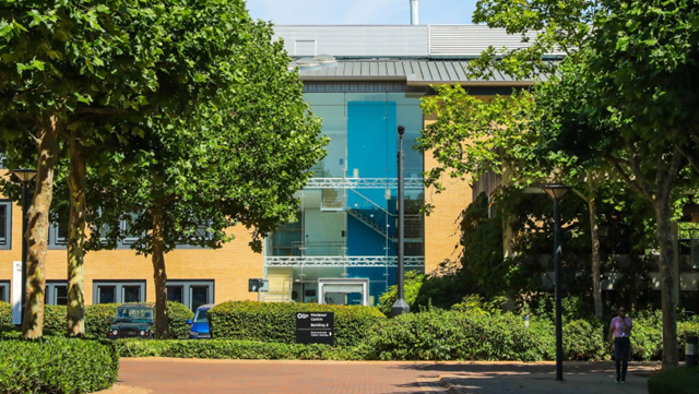 Brick exterior of Florey and John Eccles House building with trees in public realm, within Oxford Science park