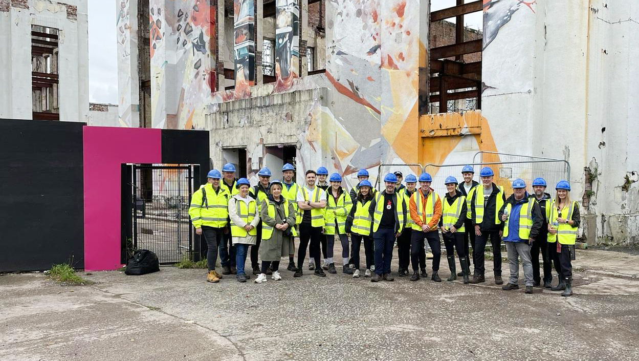 Avison Young colleagues in high visibility clothing on the site of an abandoned building at a community project