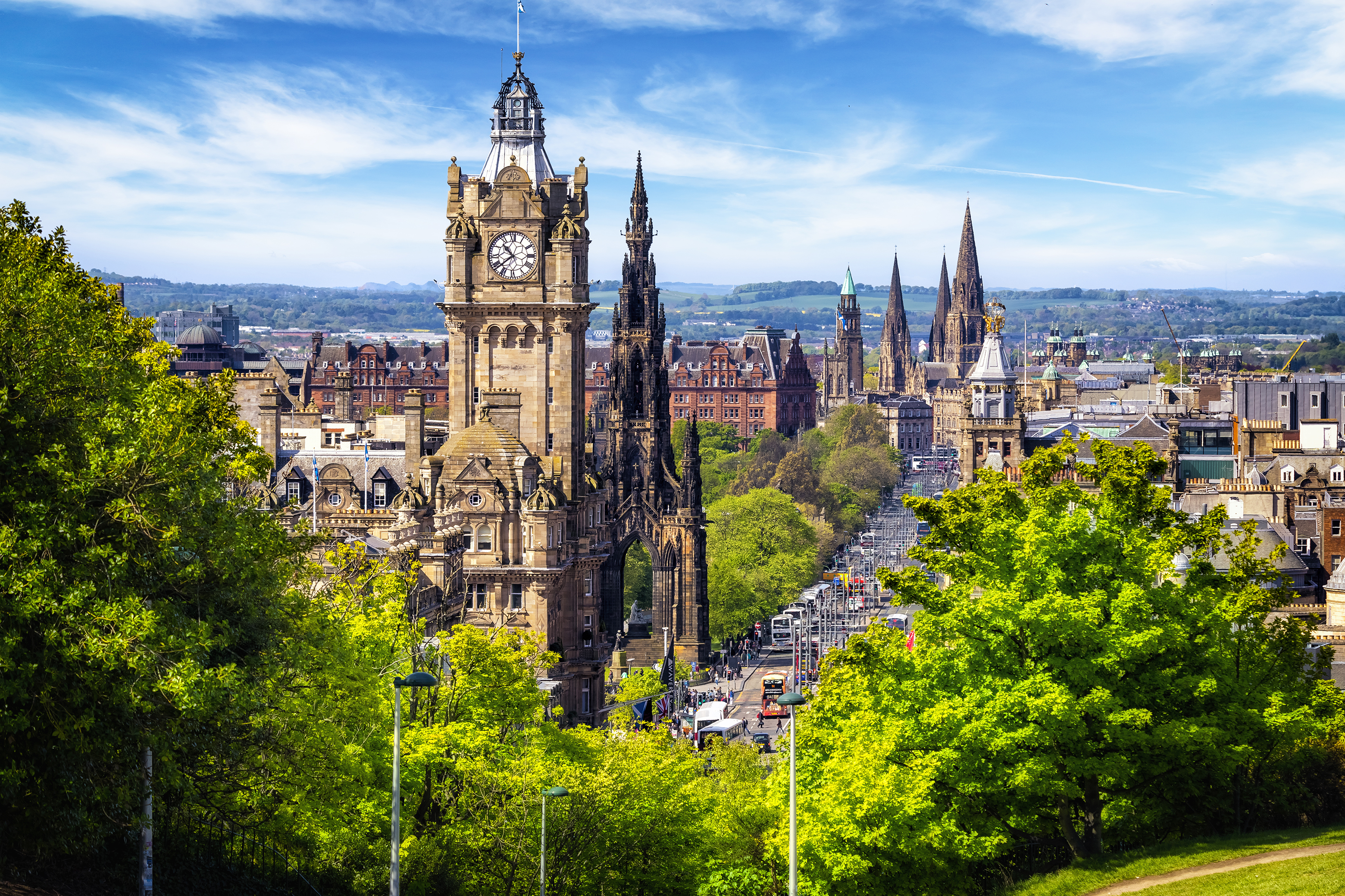 Historic monuments and buildings on Princes Street, Edinburgh Scotland with trees and parkland in foreground