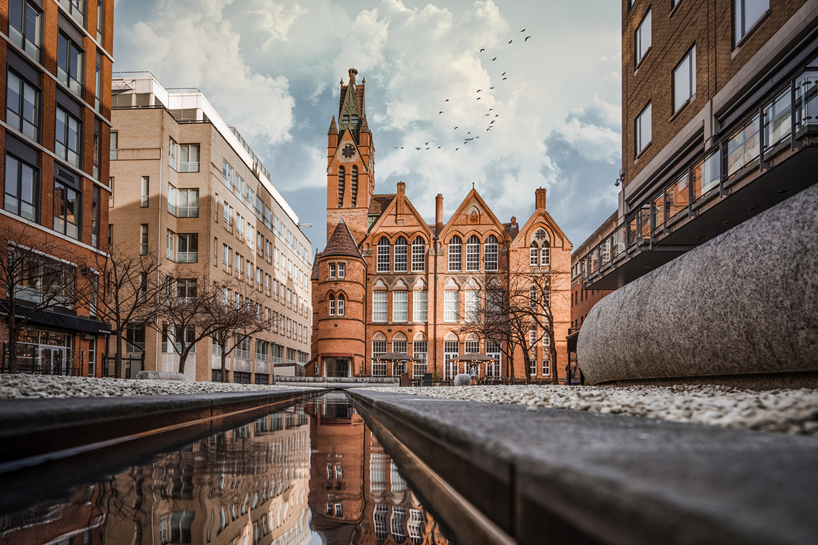 Modern commercial property beside heritage building alongside a water feature in central Birmingham with red brick facade