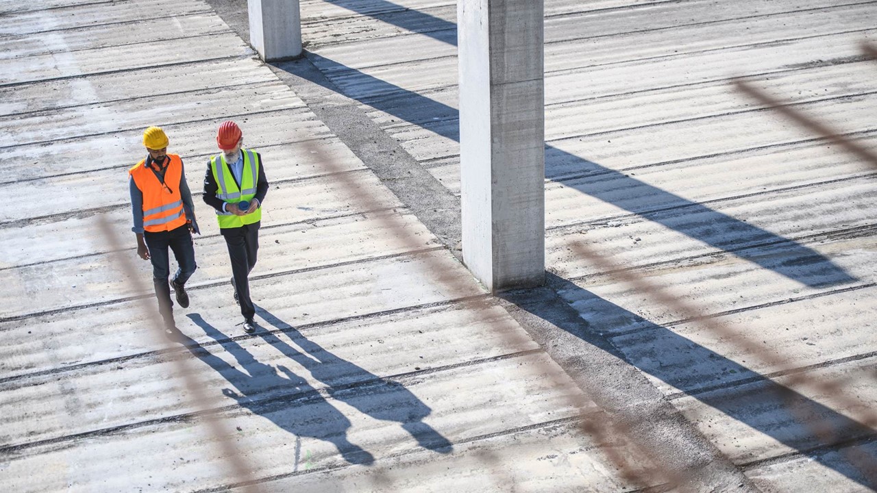 An image of two construction workers walking and talking