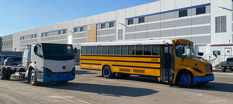 electric school bus in front of a warehouse