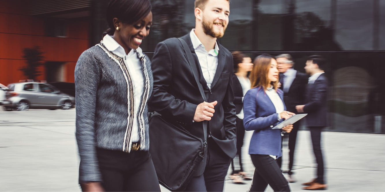 commercial real estate professionals discuss recapitalization while walking on a busy street