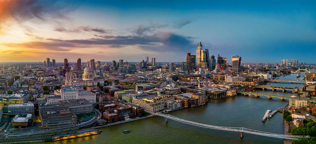 An aerial image of the London skyline with the River Thames in the foreground and skyscrapers in the distance